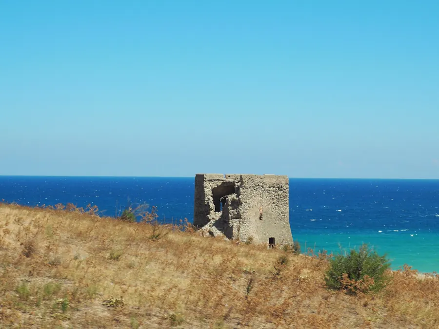 Paesaggio di mare verde acqua di Cirò Marina con Torre Vecchia di Capo Alice in primo piano