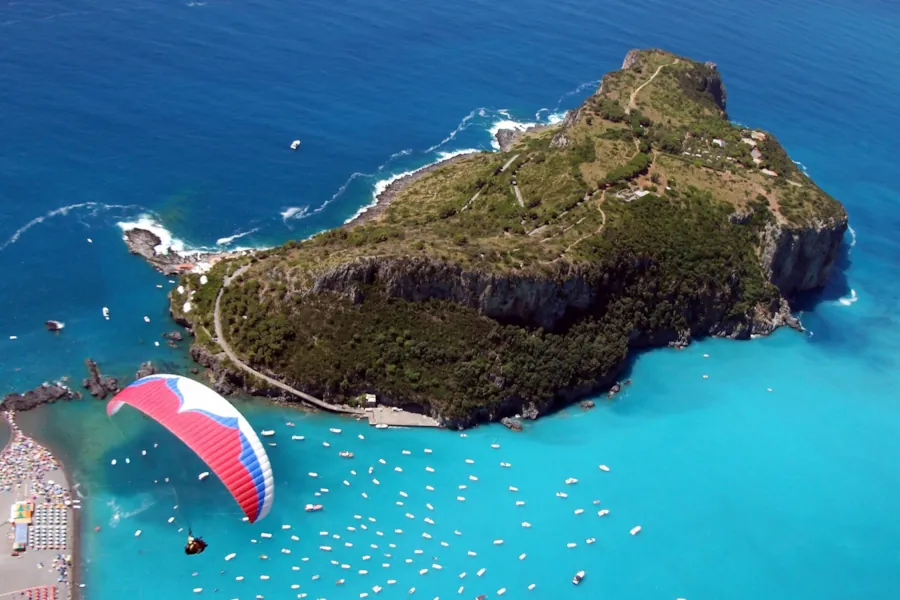 Parapendio e barche nel mare azzurro, Isola di Dino